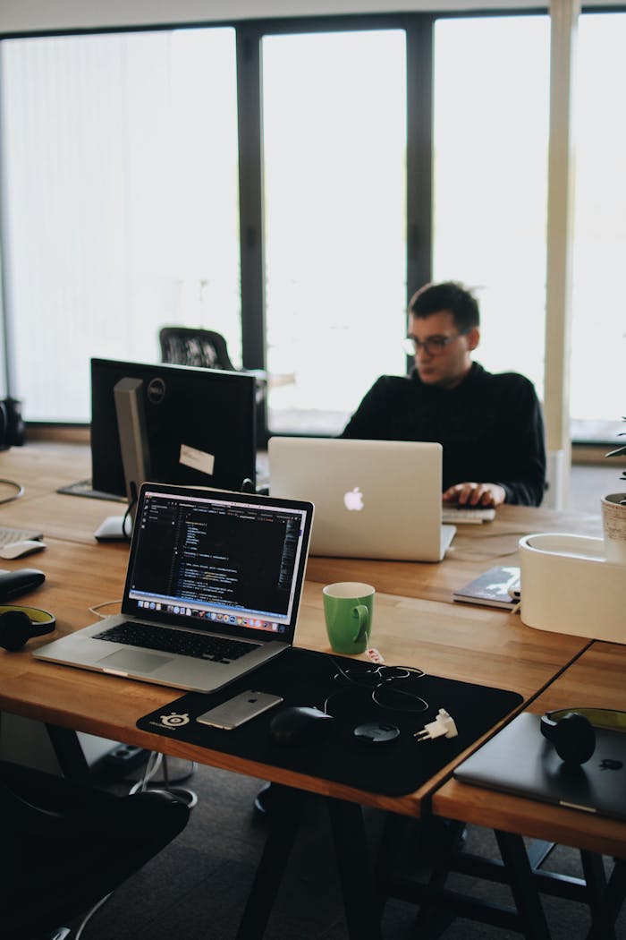 about-01 A web developer working on code in a modern office setting with multiple devices.