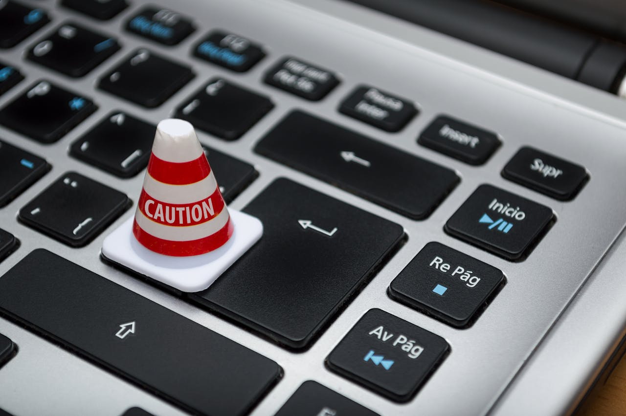 about-02 Miniature caution cone on a computer keyboard symbolizing data security and control.